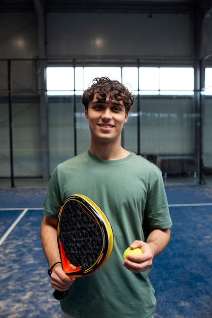 Person getting ready to play paddle tennis inside