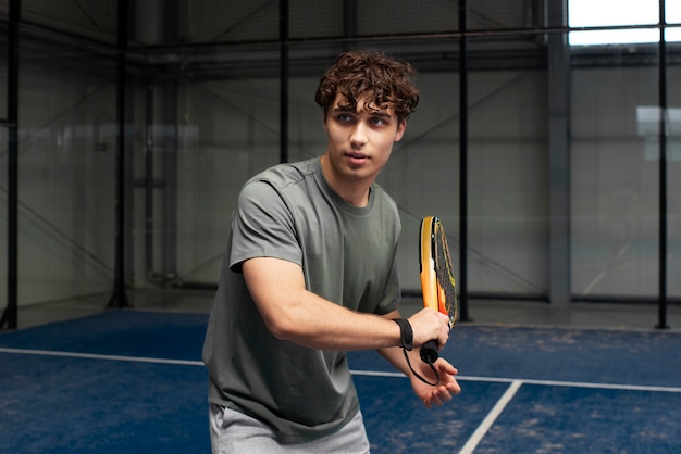 Photo person getting ready to play paddle tennis inside