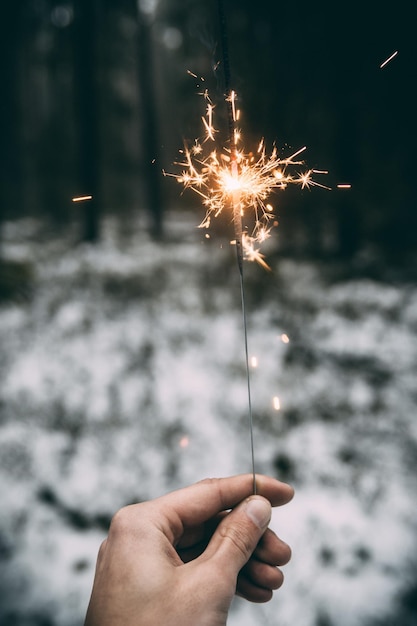 Foto persona che tiene in mano un fuoco d'artificio