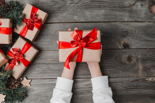 Person Hands Hold Christmas Present Wooden Surface.