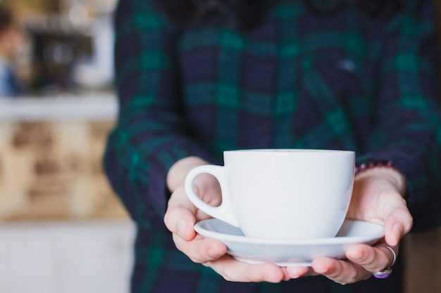 写真 手にコーヒーカップを持っている人