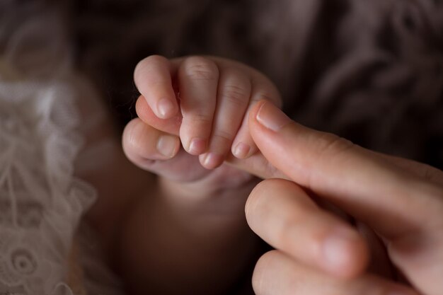 a person holding a babys finger with the finger pointing at the camera