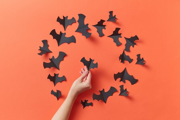 Photo person holding a black bat shaped paper cut out