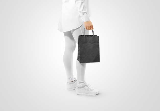 Photo person holding a blank black craft paper bag