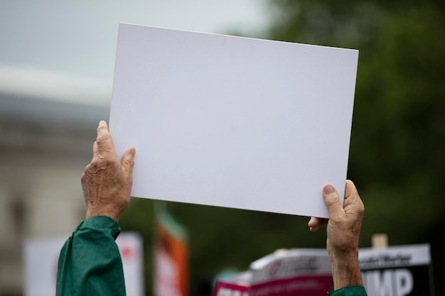 Una persona che tiene uno striscione di protesta in bianco durante una manifestazione politica