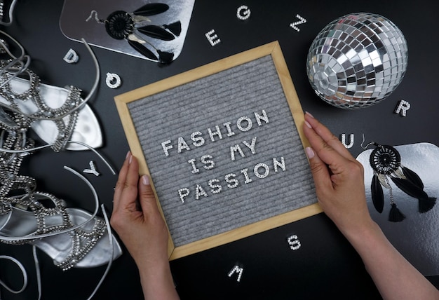 A person holding a board that says fashion is my passion.