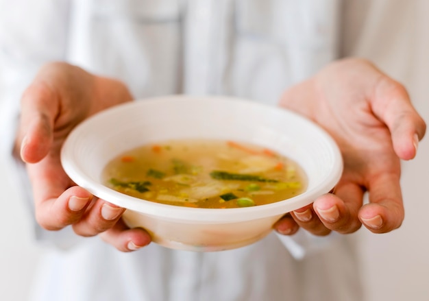 Persona che tiene la ciotola di zuppa per il giorno dell'alimento