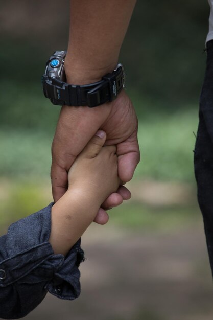 Photo a person holding a childs hand with the number 3 on it