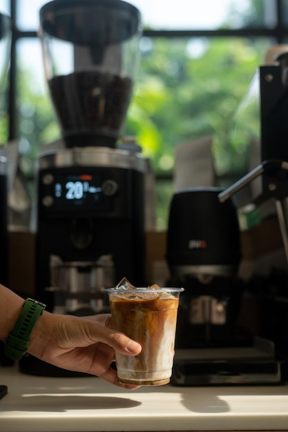 Photo a person holding a cup of iced coffee