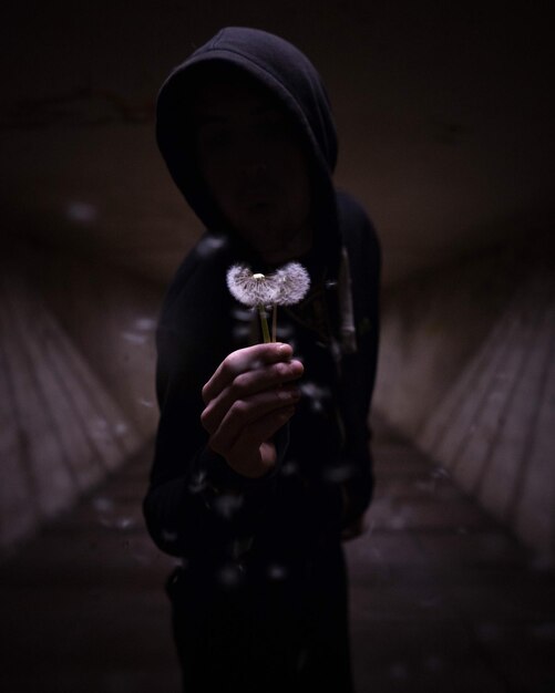 Photo person holding dandelions in tunnel