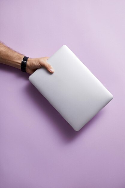 A person holding an empty white pillow on pink background.