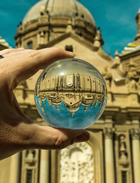 A person holding glass ball with an upside-down reflection of Saint Petersburg, Russia