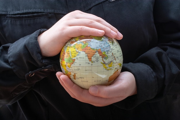 Person holding a globe model with hands