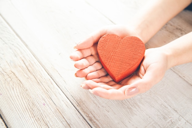 Persona in possesso di un cuore rosso fatto a mano nelle sue mani