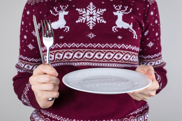 A person holding in hands plate with no food on it