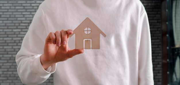 A person holding a house icon concept of sweet home safety and protection