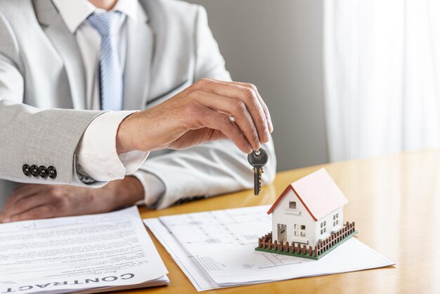 person holding house keys toy model house desk High quality beautiful photo concept