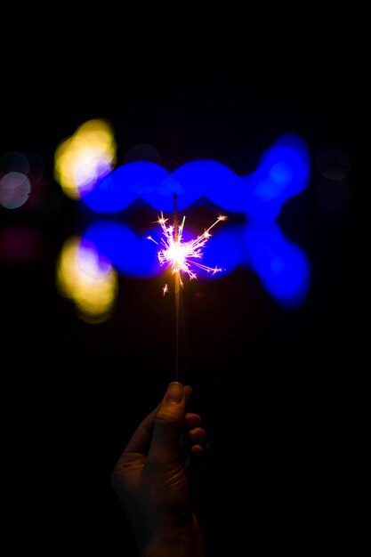 Foto persona che tiene in mano un dipinto illuminato di notte