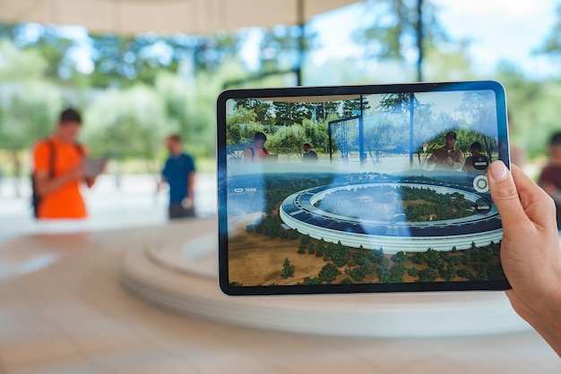 Person holding ipad live view of circular architecture at apple store mountain view ca