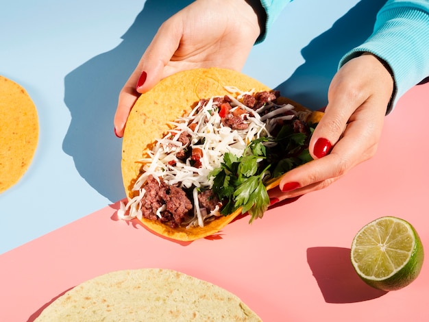 Foto persona che tiene un taco messicano nell'alta vista delle mani