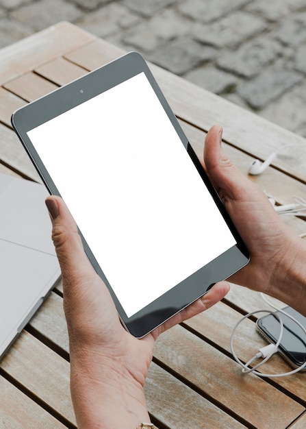 Person holding mockup tablet outdoors