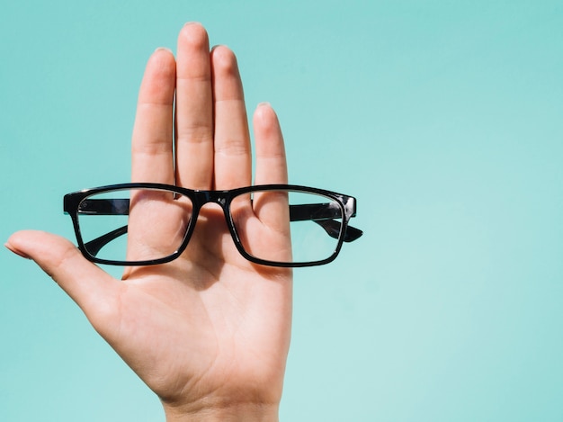 Photo person holding a pair of eyeglasses