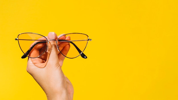 Photo person holding a pair of modern eyeglasses