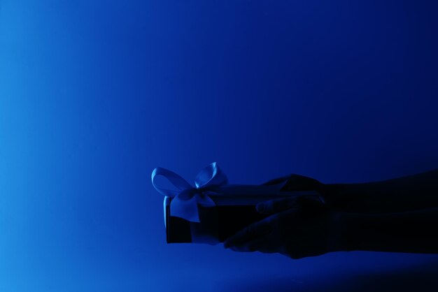 Person holding paper against blue background