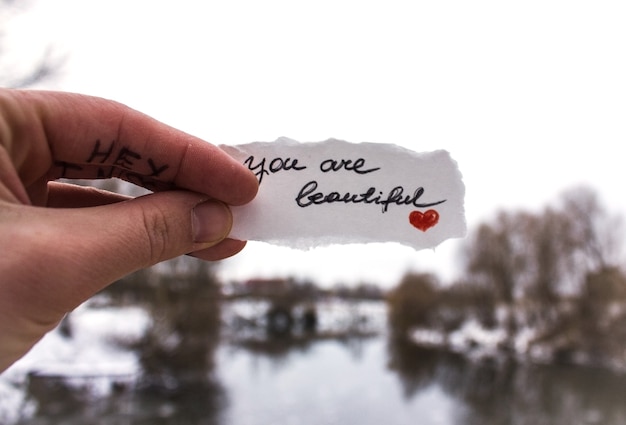 Photo person holding paper with you are beautiful inscription