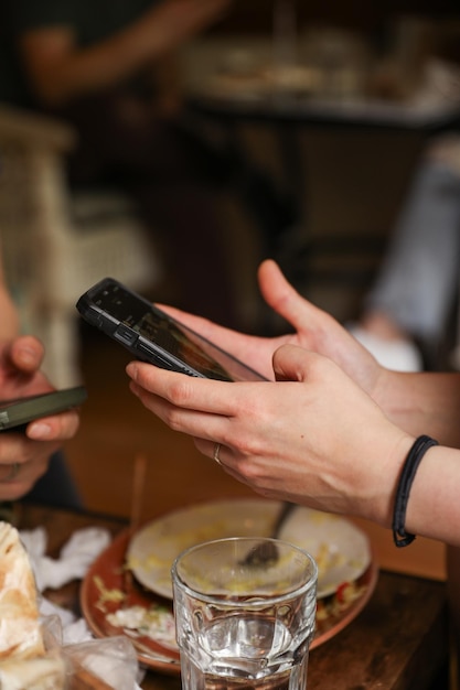 A person holding a phone at the table symbolizing connectivity communication and the integration