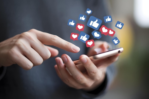 Facebookという単語を含むアプリのような多くのアイコンを備えたスマートフォンを保持している人