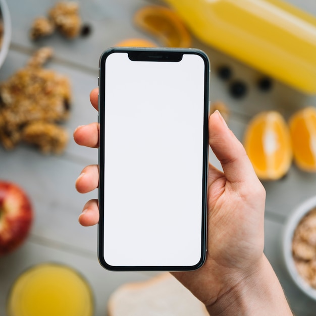 Photo person holding smartphone with blank screen above fruits