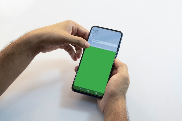 person holding a smartphone with green screen
