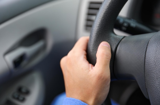 A person holding a steering wheel in a car