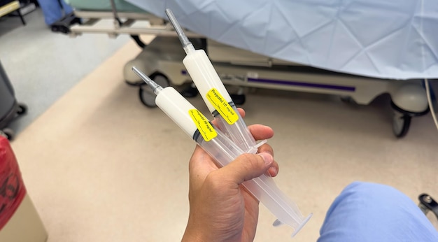 A person holding a syringe with a yellow sticker that says'no injections'on it