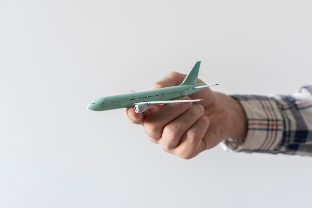 A person holding a toy airplane as the symbol of travel and transportation