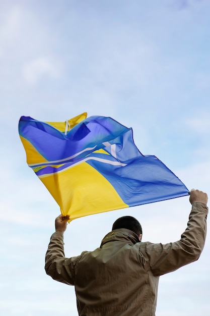 Photo person holding ukrainian flag