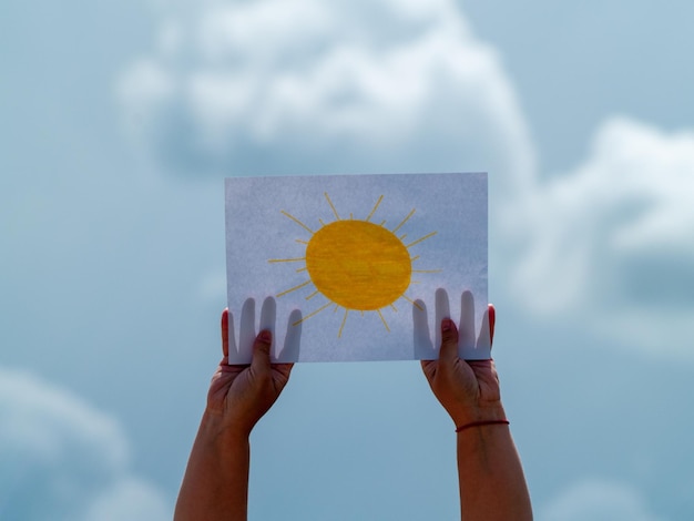 Photo person holding umbrella against sky