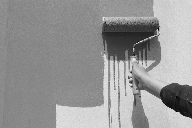 Person holding umbrella against wall