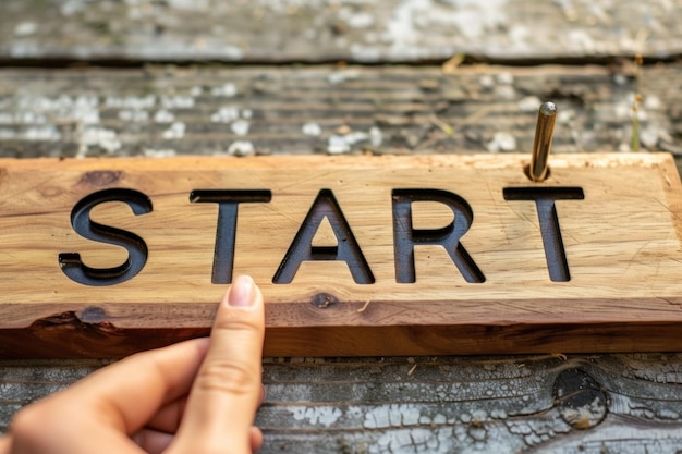 Photo person holding wooden sign that says start