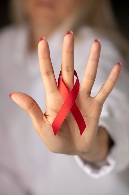 Photo person holding an world aids day ribbon symbol