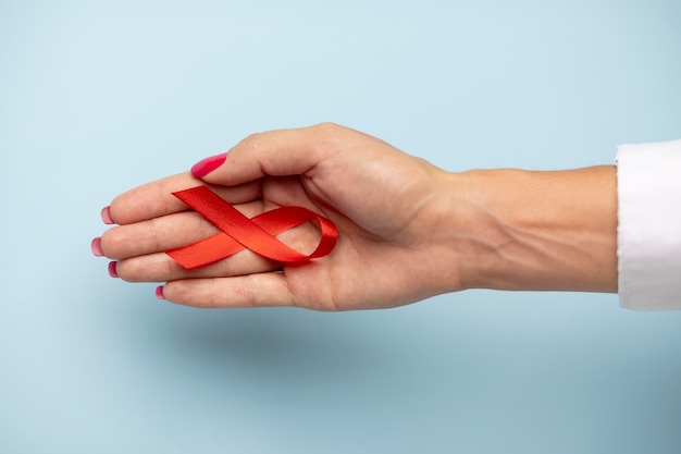 Persona in possesso di un simbolo del nastro della giornata mondiale contro l'aids