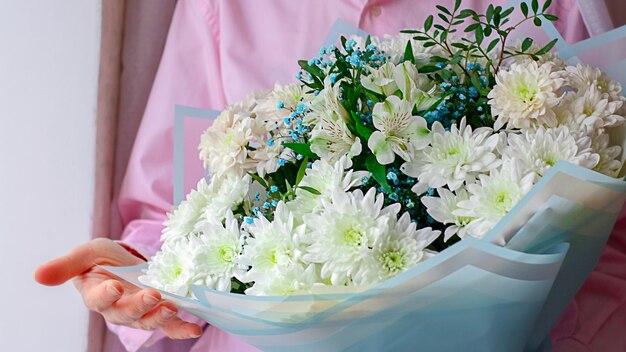 A person holds a bouquet of different flowers in his hands the concept of congratulations