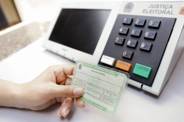 Person holds the Electoral Title Voter License mandatory item in Brazilian elections