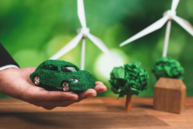 A person holds a green car made of legos.