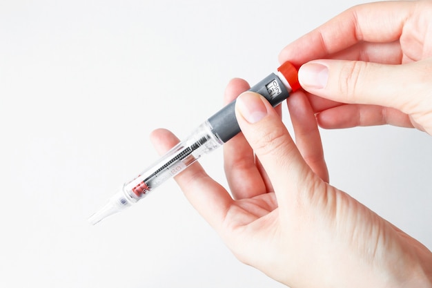Photo the person holds the insulin pen for the injection and sets the dose of the medication