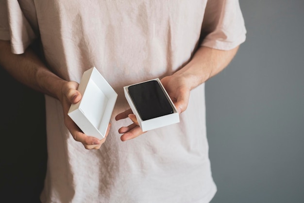 Photo a person holds the new smartphone box or case and unpack it holiday surprise present concept