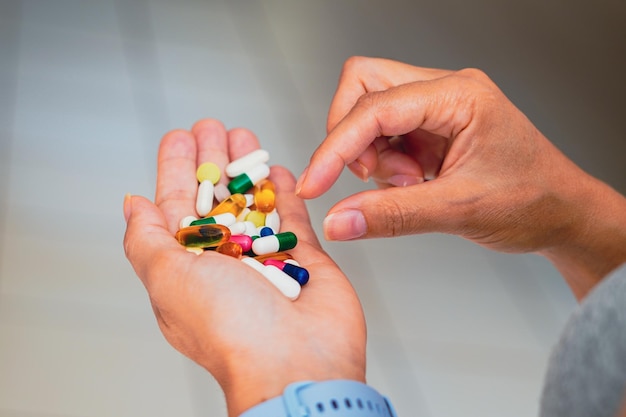 Photo a person holds several medicine pills in his hand