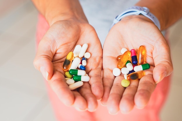 Photo a person holds several medicine pills in the palm of both hands