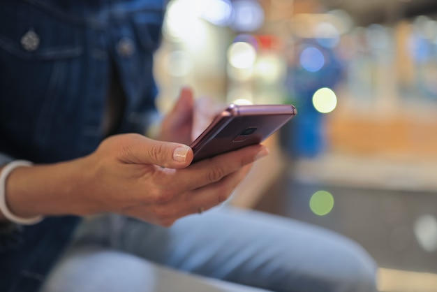 Photo person holds smartphone in his hands and moves his finger across screen